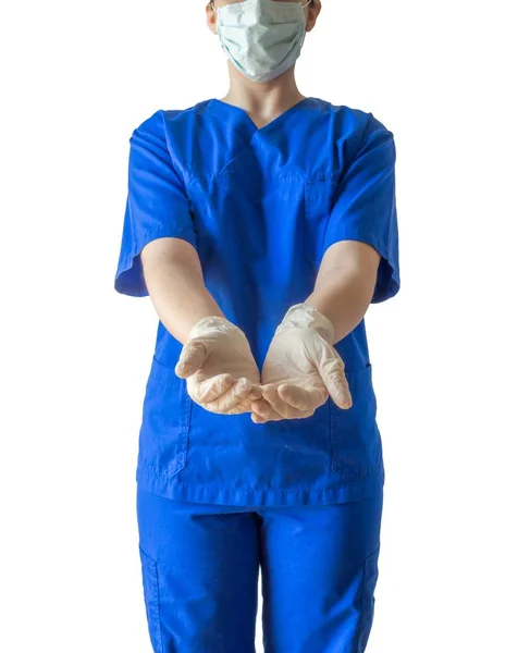 Joven doctora de éxito en un uniforme médico azul y una máscara que muestra manos vacías por ayudar. — Foto de Stock