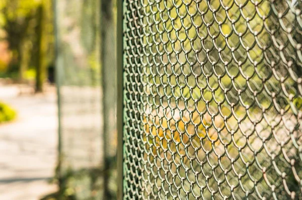 Foto de cierre de una valla de eslabón exterior de cadena con un fondo borroso. — Foto de Stock