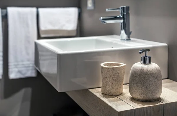 Foto más baja de un lavabo moderno junto a la botella en el cuarto de baño. — Foto de Stock