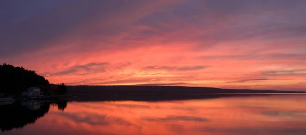 Meereslandschaft umgeben von Hügeln unter wolkenverhangenem Himmel während des Sonnenuntergangs — Stockfoto