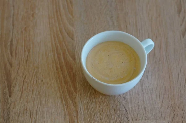 Eine Hochwinkelaufnahme Einer Gefüllten Weißen Kaffeetasse Auf Einer Holzoberfläche — Stockfoto