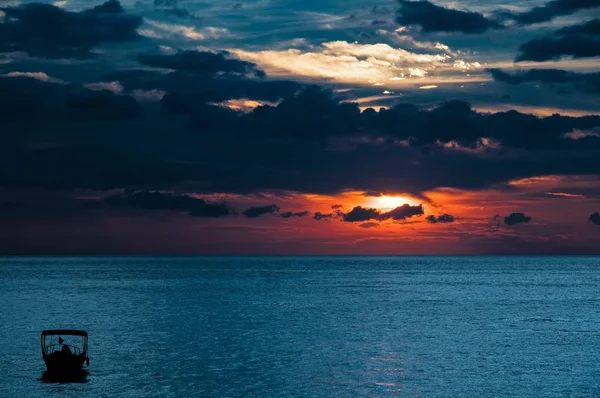 Beautiful shot of a sunrise in the ocean with a cloudy sky — Stock Photo, Image