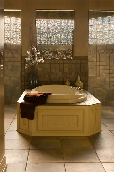 Bañera bajo las lámparas rodeada de espejos y paredes marrones en el baño — Foto de Stock