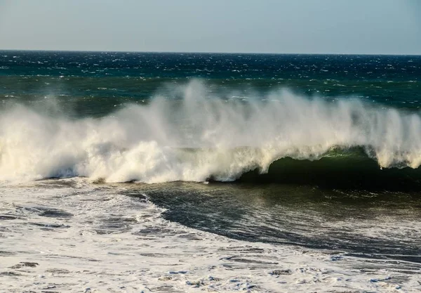 Paisagem tiro de ondas marinhas fortes na praia com um céu limpo — Fotografia de Stock