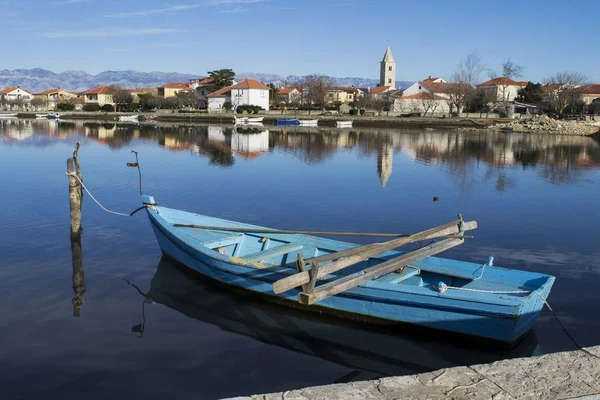 Blue boat tied off along the dock in a village — Stock Photo, Image