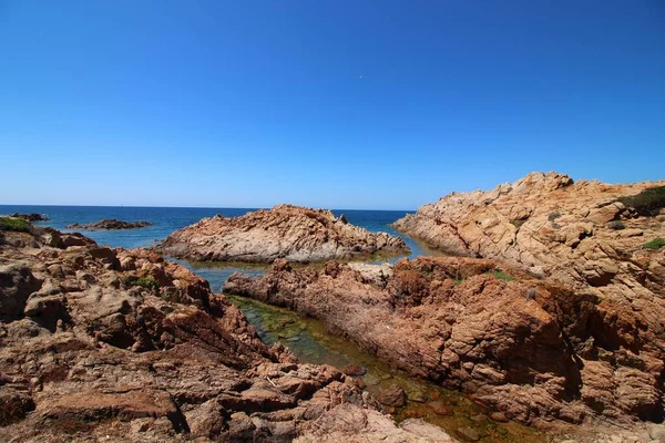 Krajina záběr na pobřeží s velkými skalami na jasně modré obloze — Stock fotografie