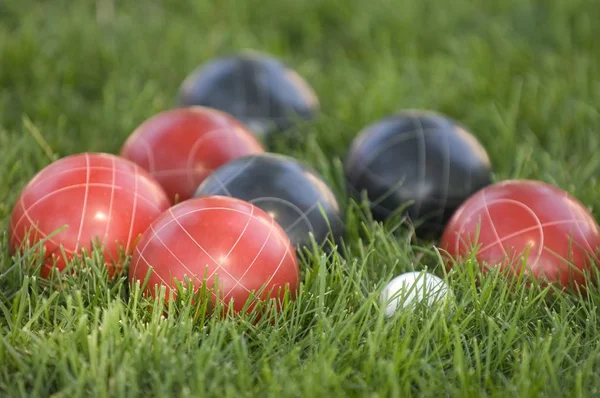 Imagem de bolas coloridas bocce no gramado sob a luz do sol com um fundo borrado — Fotografia de Stock