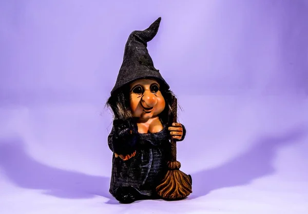 Paisagem tiro de um brinquedo de bruxa anã com uma cor roxa no fundo — Fotografia de Stock