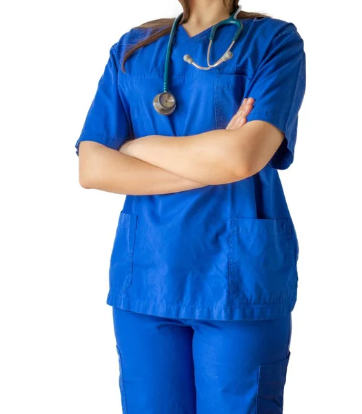 Junge Ärztin in blauer Arztuniform steht selbstbewusst mit verschränkten Händen da — Stockfoto
