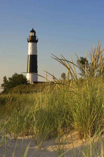 Grand phare de Sable Point entouré de verdure et de sable sous la lumière du soleil dans le Michigan — Photo