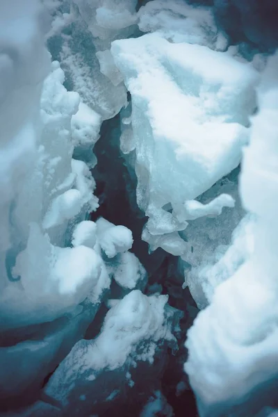 Karla kaplı zemindeki buz yarığının dikey yakın çekimi. — Stok fotoğraf