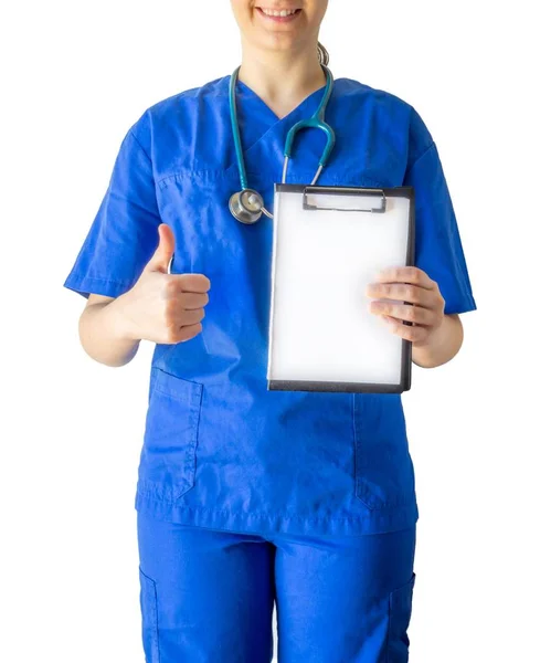 Kvinna läkare i en medicinsk uniform som håller ett tomt vitt papper med en kopia utrymme visar en tummen upp — Stockfoto