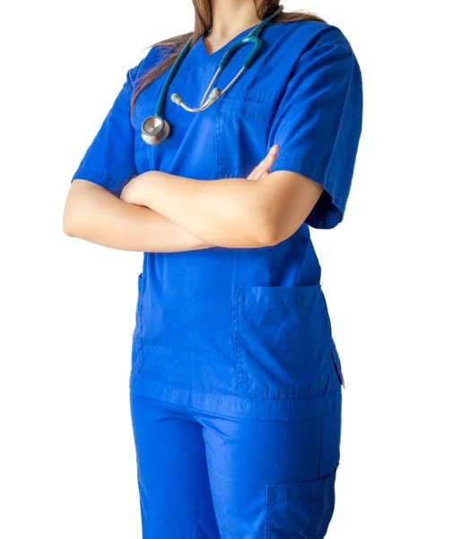 Jonge vrouwelijke arts in een blauw medisch uniform staat vol vertrouwen met gekruiste handen — Stockfoto