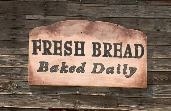 Een Vers Brood Gebakken Dagelijks Teken Een Houten Muur Onder — Stockfoto