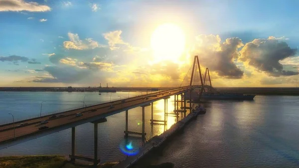 Autos fahren auf einer Brücke mit dem schönen Sonnenuntergang im Hintergrund in Charleston, South Carolina — Stockfoto