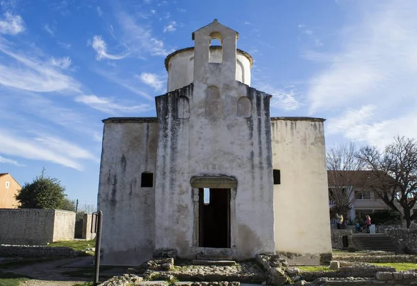 Photo prise à angle bas de l'église Sainte-Croix à Nin, en Croatie, contre un ciel bleu et nuageux — Photo