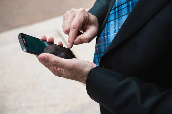 Homem em um terno e gravata usando seu smartphone — Fotografia de Stock