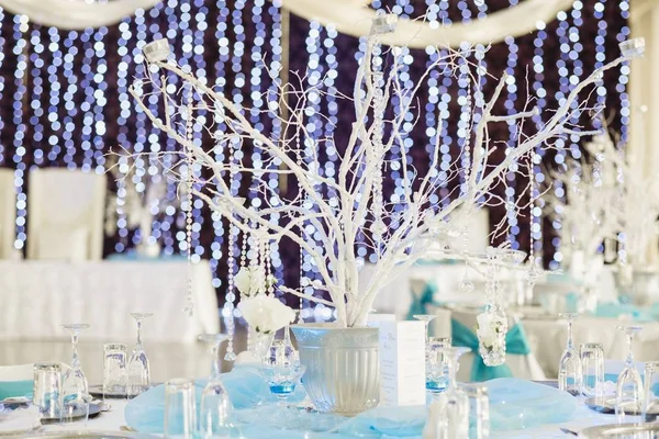Beautiful elegant white decorations of a wedding table in an illuminated hall — Stock Photo, Image