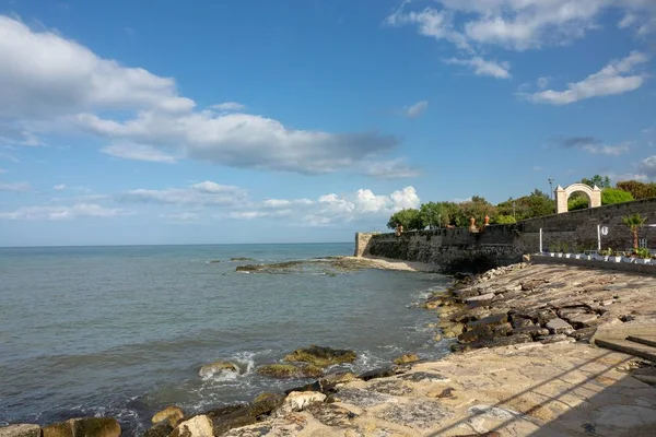 Plan grand angle d'un mur qui fait le tour de la plage sous un ciel plein de nuages — Photo