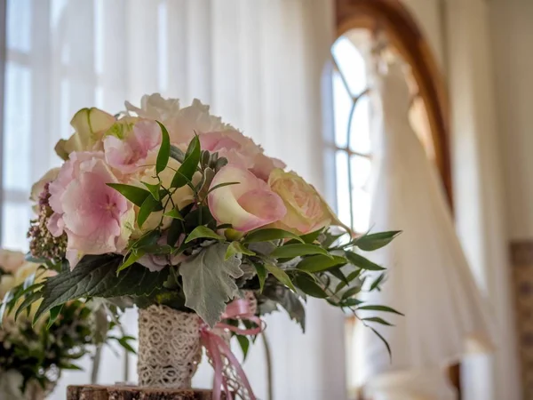 Buquê de flores em um vaso sob as luzes cercado por janelas com um fundo embaçado — Fotografia de Stock