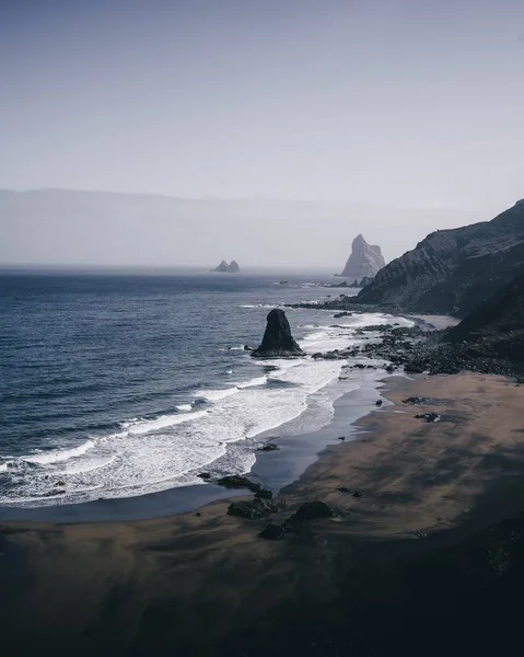 Svislý vysoký úhel záběru skalnatého břehu moře v ponurý den — Stock fotografie