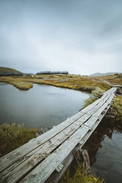 Vertical shot fo a wooden dock over a lake in Finse, Noruega. — Foto de Stock