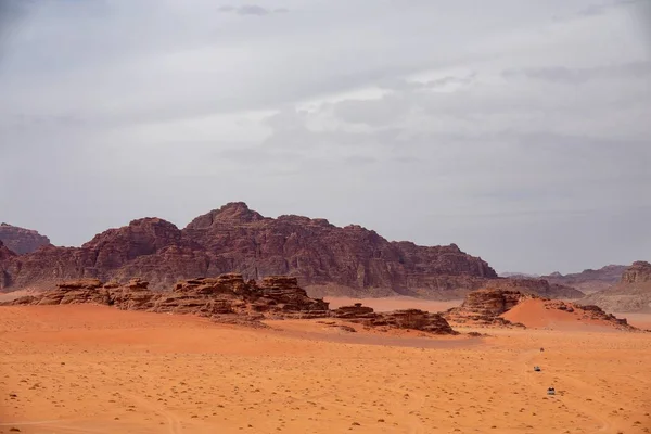 Grande ângulo de tiro de vários penhascos grandes em um deserto sob um céu nublado — Fotografia de Stock