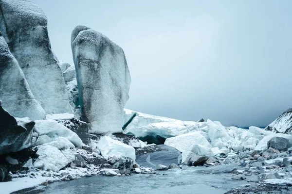 Lindas paisagens de enormes formações rochosas cobertas de neve perto de um rio em Finse, Noruega — Fotografia de Stock