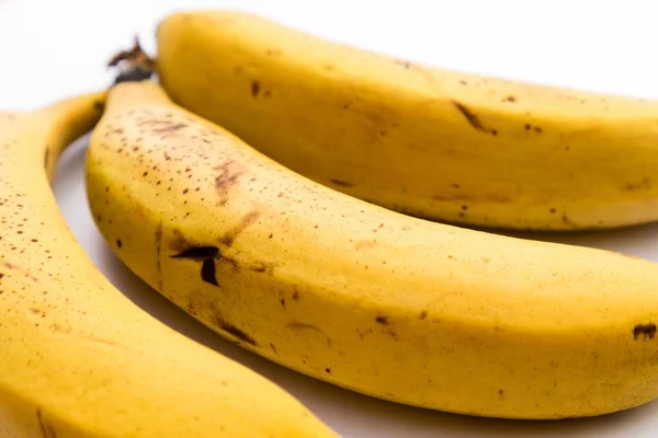 Zbliżenie Ujęcia Trzech Bananów Białej Powierzchni — Zdjęcie stockowe