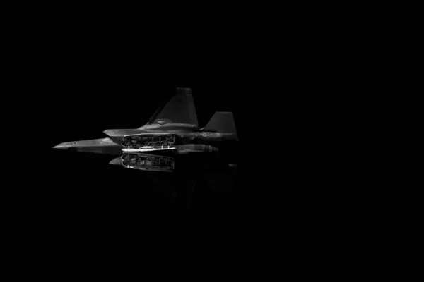 Baixo ângulo de tiro de um único avião de caça a jato no fundo escuro — Fotografia de Stock