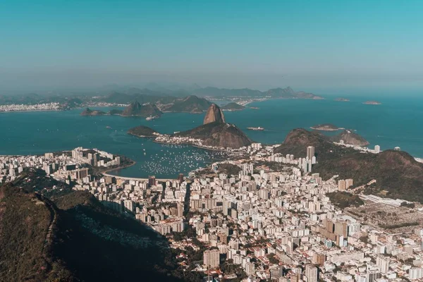 ブラジルの青い空の下、丘や海に囲まれたリオデジャネイロの空中写真 — ストック写真