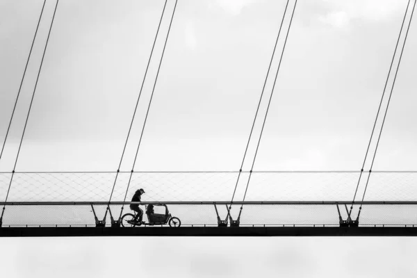 曇った空の下、橋の上で自転車に乗る者 — ストック写真