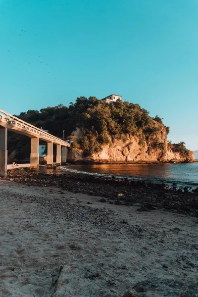 ブラジルの橋で覆われた緑に覆われた海と岩に囲まれたビーチ — ストック写真
