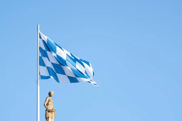 Biała Flaga Niebieskimi Kwadratami Afiszującymi Się Wietrze Pod Błękitnym Niebem — Zdjęcie stockowe