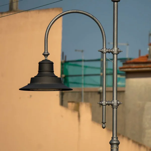 Cerradura de una lámpara de metal conectada a una pared durante el día. —  Fotos de Stock