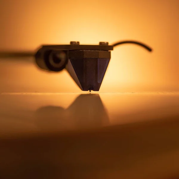 Közelkép egy narancssárga hátterű gramofon tűről — Stock Fotó