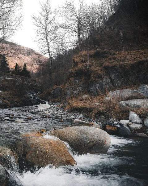 Tiro vertical de alto ângulo de pedras no rio que flui nas montanhas — Fotografia de Stock