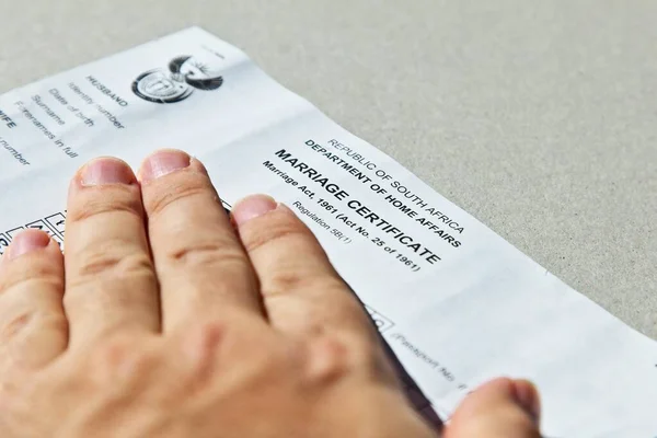 Una mano con un certificado oficial de matrimonio sudafricano —  Fotos de Stock