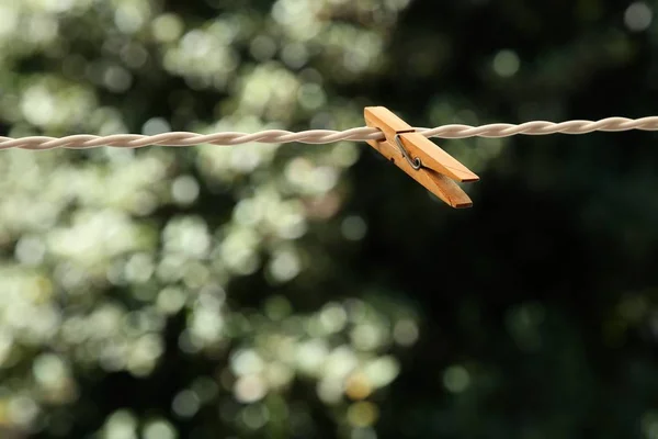 Foto selectiva de enfoque de un pañuelo de madera sobre un alambre con un fondo natural borroso. —  Fotos de Stock