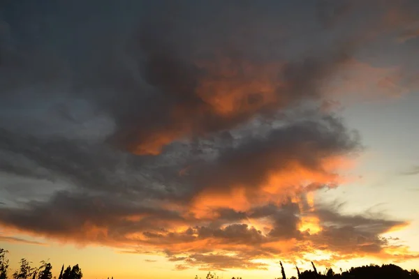 Céu apedrejador durante o pôr do sol com cores rosa e amarelo alaranjadas — Fotografia de Stock