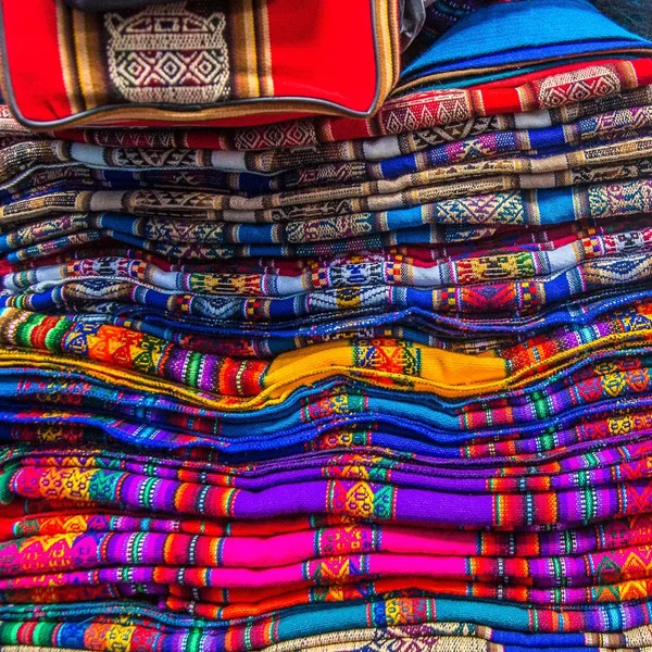 Beaux tissus artisanaux empilés les uns sur les autres dans un marché — Photo
