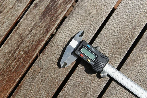 Foto en ángulo alto de un calibre digital en una superficie de madera. — Foto de Stock