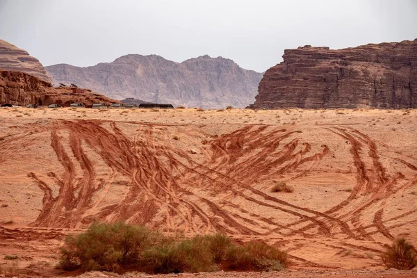 Falésias e cavernas em um deserto cheio de grama seca sob um céu nublado durante o dia — Fotografia de Stock