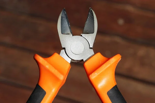 Selective focus shot of diagonal pliers over a wooden surface — Stock Photo, Image