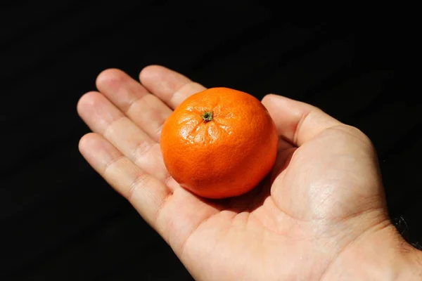 Eine Hochwinkelaufnahme Einer Person Die Eine Mandarine Über Einem Dunklen — Stockfoto