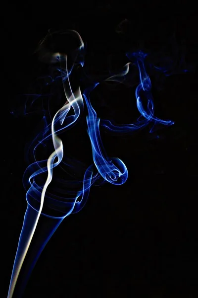 Incrível tiro de fumaça com uma luz azul em um fundo preto — Fotografia de Stock
