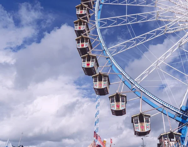 Foto de ángulo bajo de un carrusel circular que gira bajo un cielo lleno de nubes. — Foto de Stock