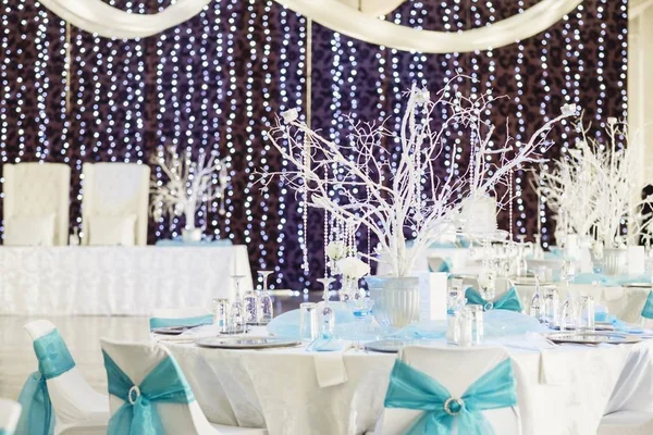 Hermosas decoraciones blancas elegantes de una mesa de bodas en una sala iluminada — Foto de Stock