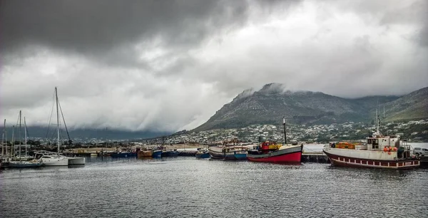Largo ángulo de tiro de barcos alrededor de las montañas bajo un cielo nublado. —  Fotos de Stock