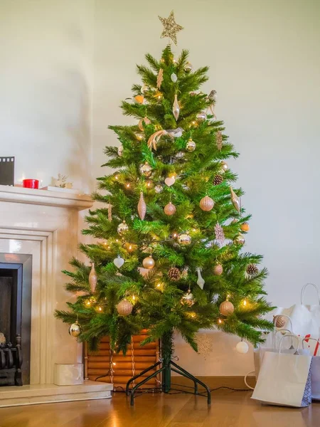 Imagem vertical de uma árvore de Natal decorada com luzes e ornamentos em uma casa — Fotografia de Stock